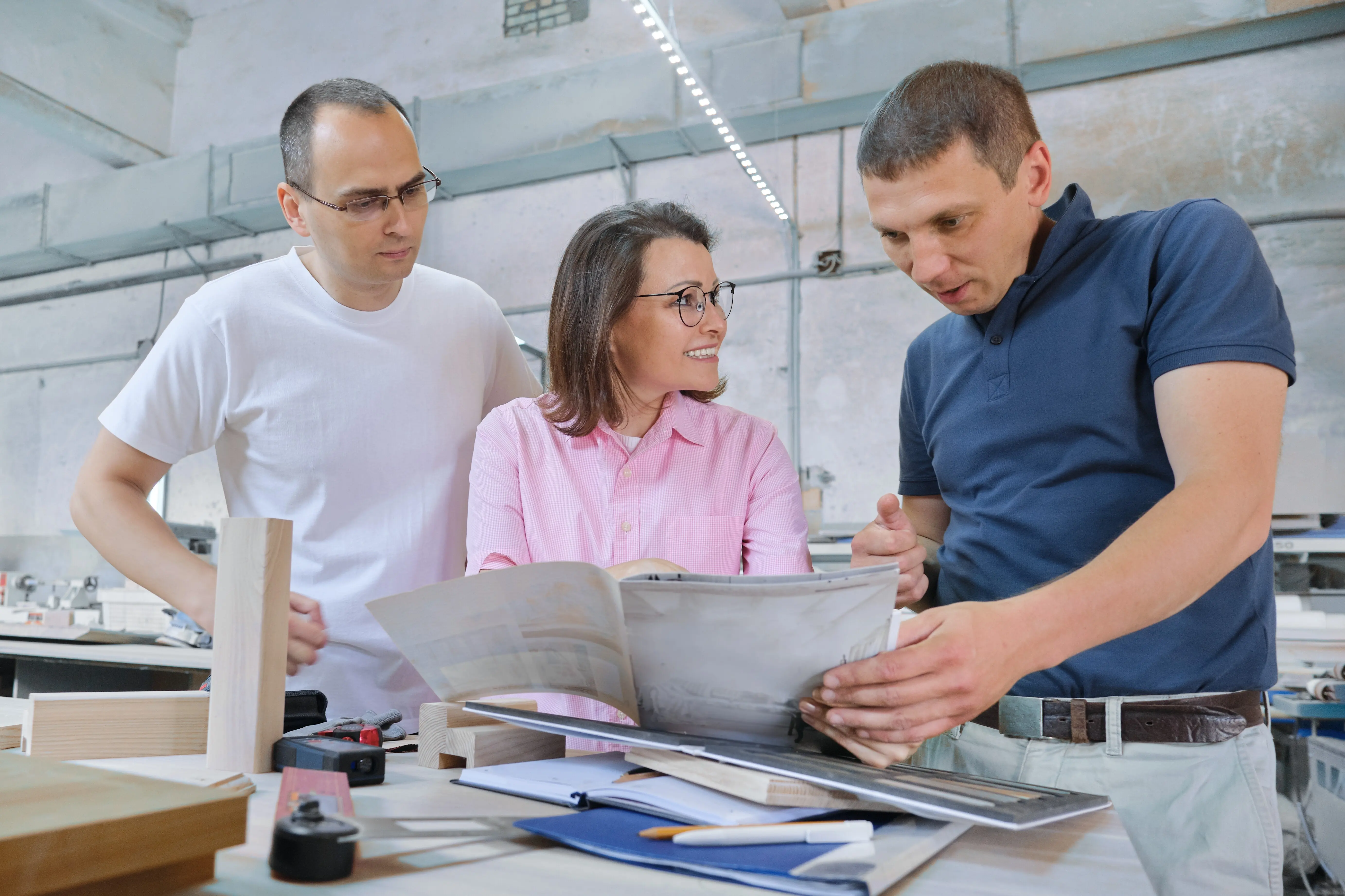 Gruppe arbeitender Menschen, die den Arbeitsprozess besprechen.